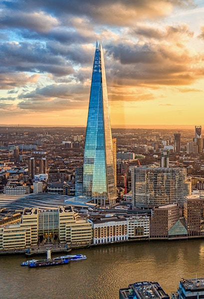 The Shard skyscraper in London at sunset with cityscape and river views.