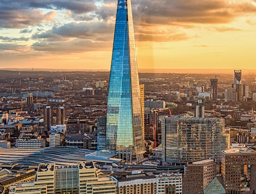 The Shard skyscraper in London at sunset with cityscape and river views.