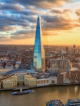 The Shard skyscraper in London at sunset with cityscape and river views.