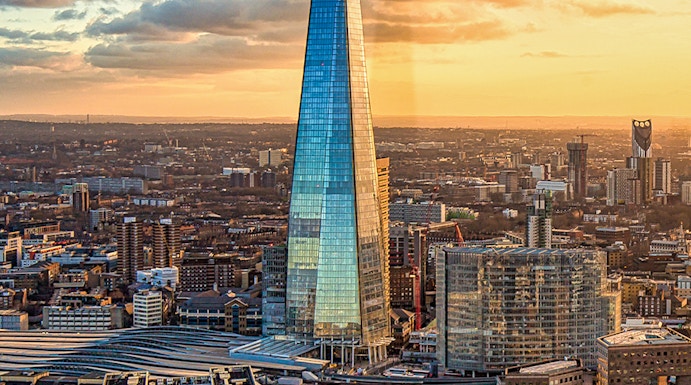 The Shard skyscraper in London at sunset with cityscape and river views.