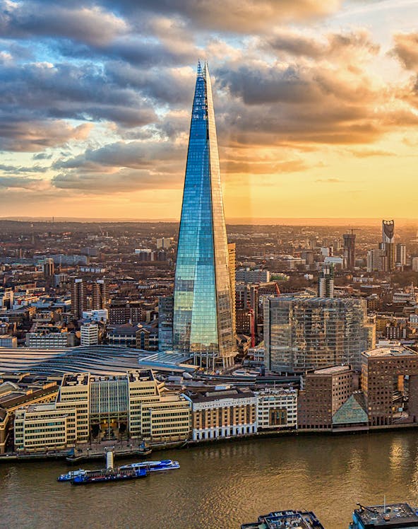 The Shard skyscraper in London at sunset with cityscape and river views.