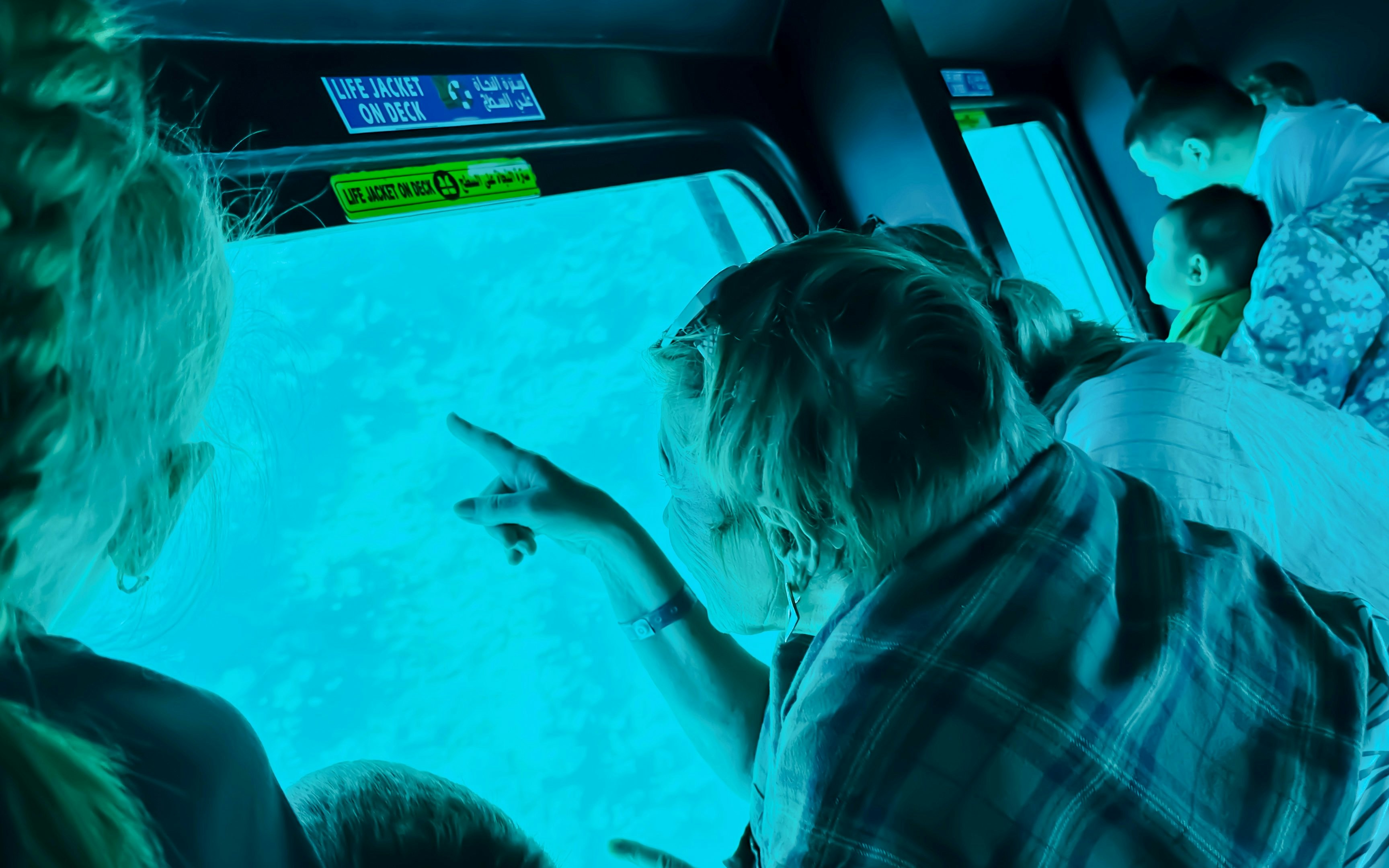 Family observing fish through submarine window on Royal Seascope, Hurghada.