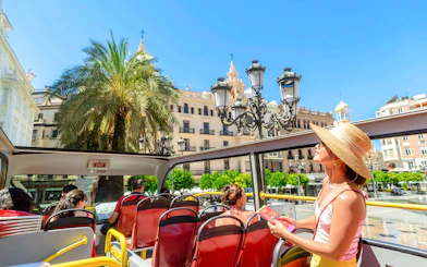 Tourist on Cordoba sightseeing bus viewing historic architecture.