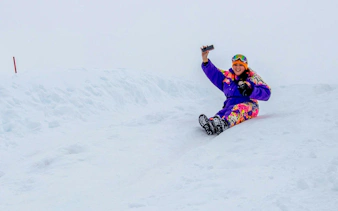 Tourist sliding on snow at Valle Nevado, Chile, capturing a selfie.