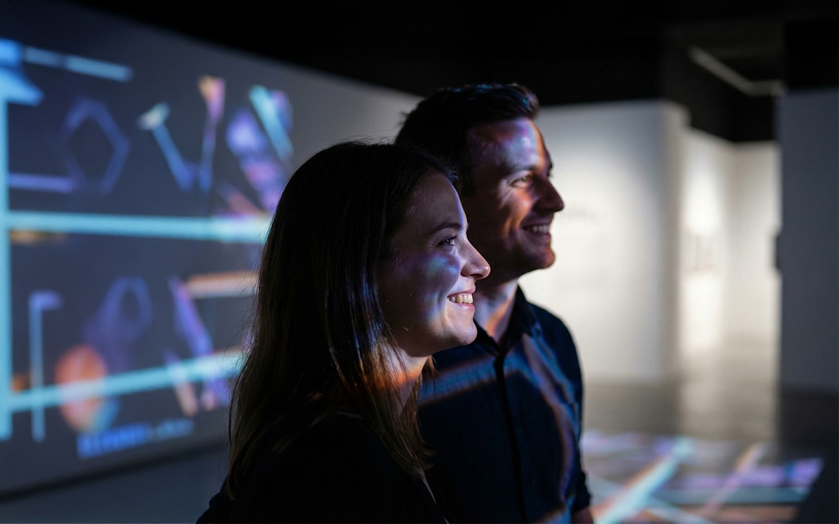 Couple enjoying digital art projections at an exhibition.
