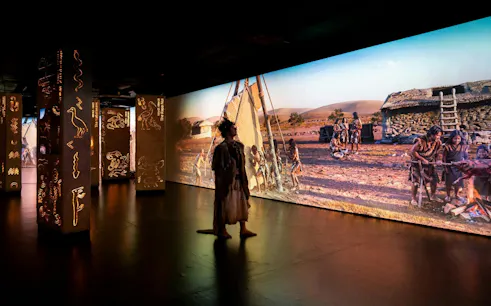 Timewalk Exhibition at Immerse LDN showcasing prehistoric village scene.
