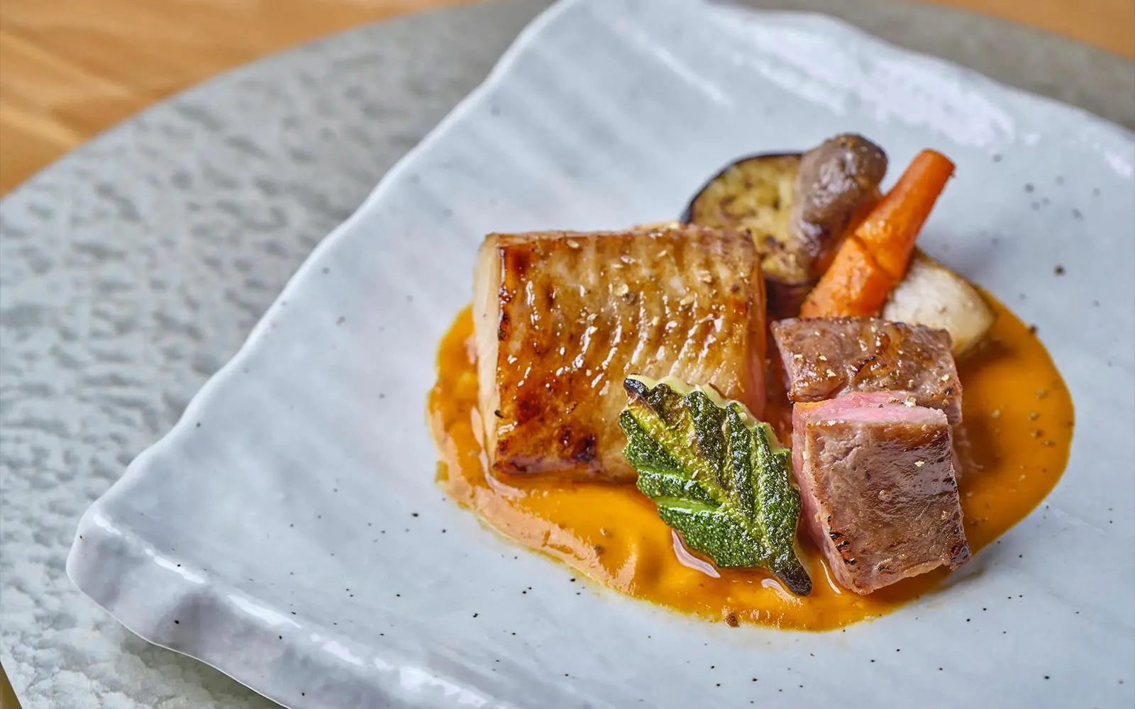 Grilled meat with vegetables on a white plate, Okura Cruise Bangkok dining.