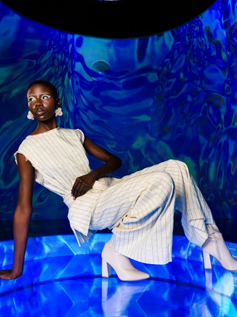 Person posing in a futuristic blue-lit room at AYA Universe.