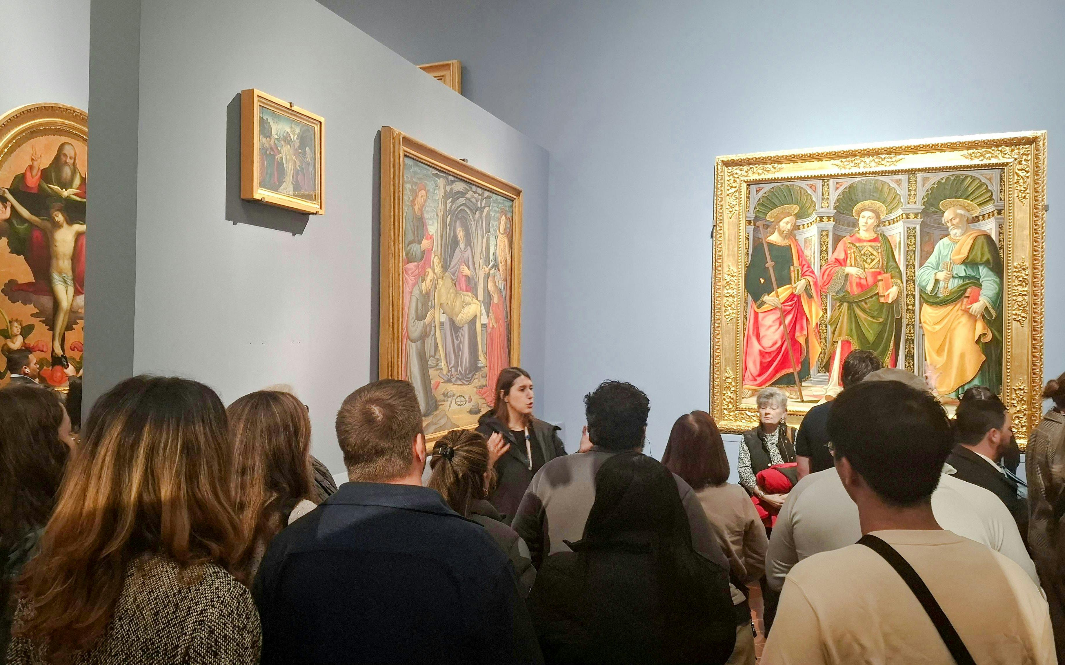 Visitors viewing Renaissance paintings at Florence's Accademia Gallery.