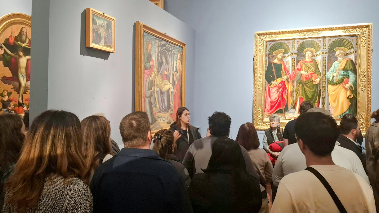 Visitors viewing Renaissance paintings at Florence's Accademia Gallery.
