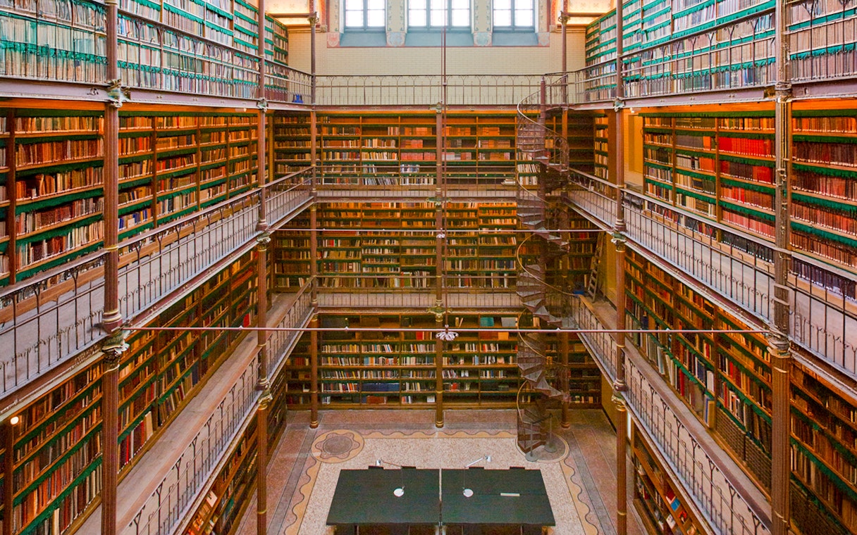 Rijksmuseum Cuypers Library interior with spiral staircase and bookshelves.