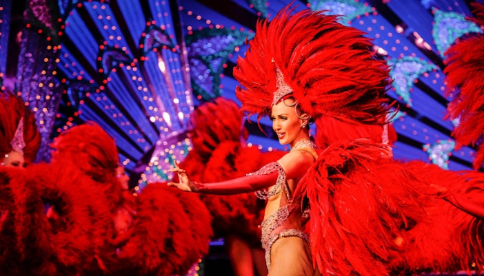 Moulin Rouge cabaret show with dinner in Paris, featuring vibrant costumes and lively performances.