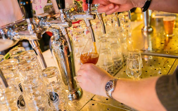 Pouring craft beer from a tap during a brewery tour.