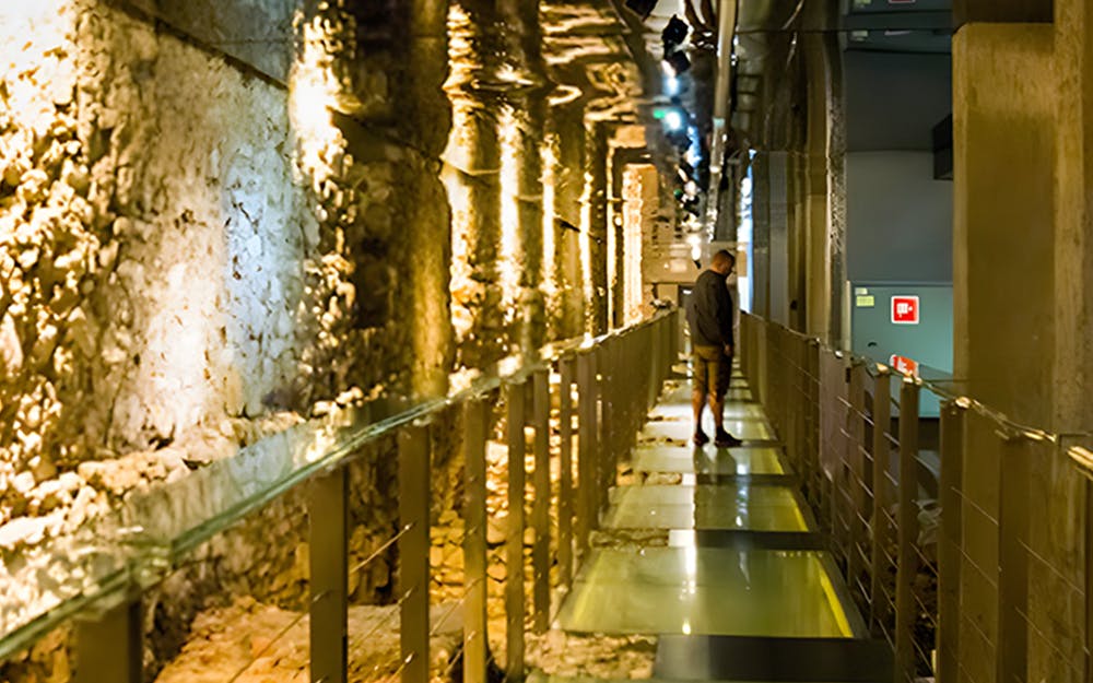 Visitors exploring exhibits at Rynek Underground Museum, Krakow, showcasing medieval market history.