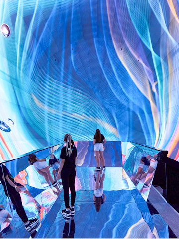 Visitors exploring immersive digital art installation in Budapest museum.