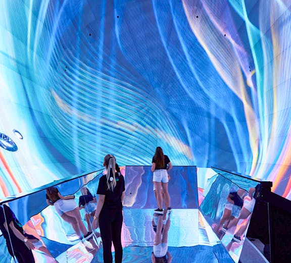 Visitors exploring immersive digital art installation in Budapest museum.