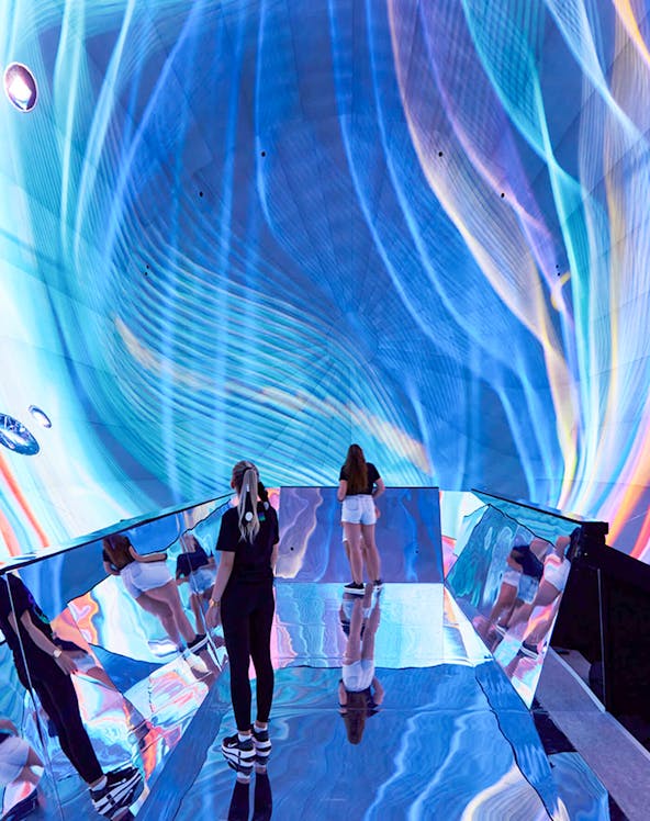 Visitors exploring immersive digital art installation in Budapest museum.