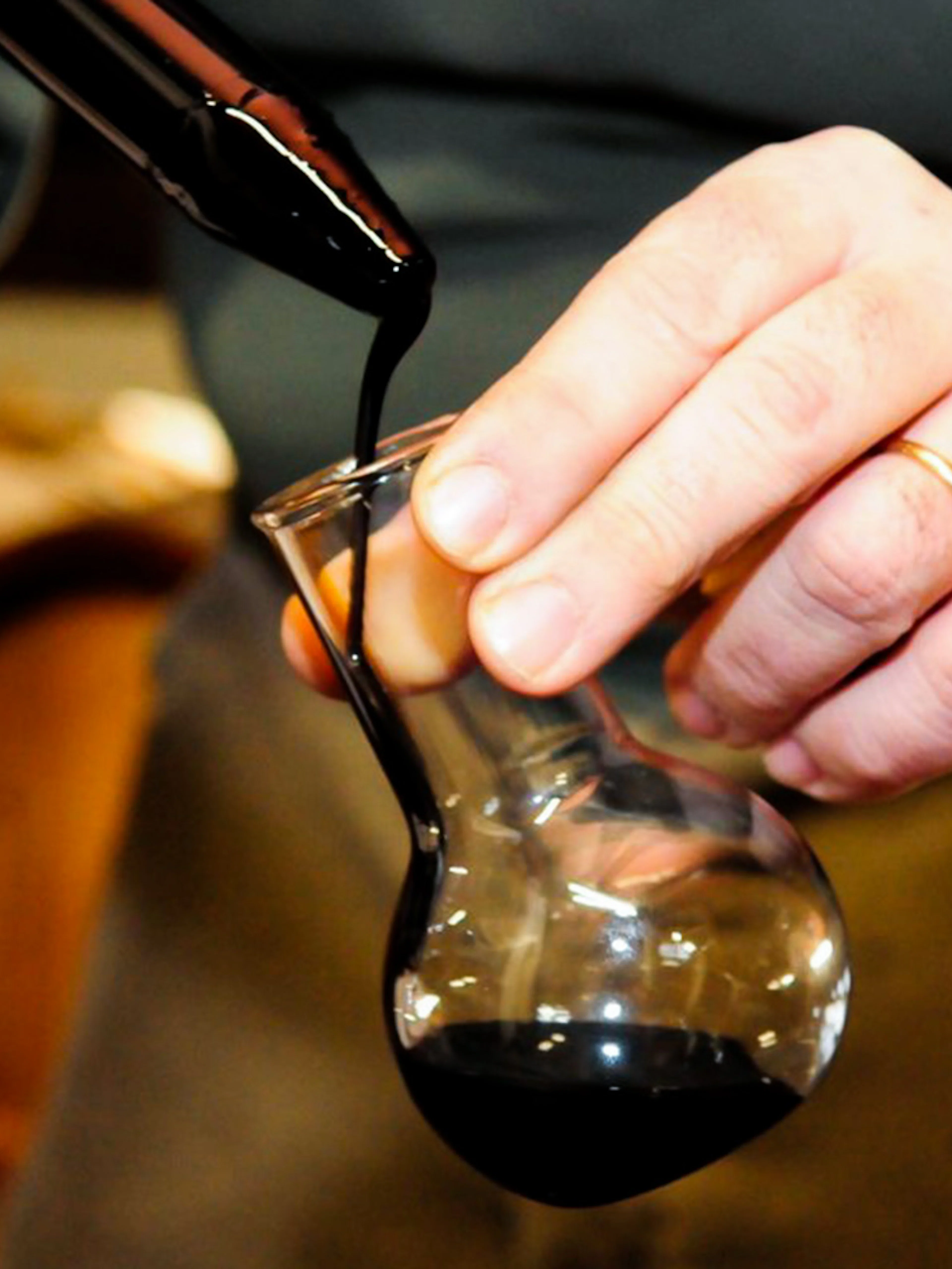 Pouring vinegar into a glass during a guided cellar tour with tastings.