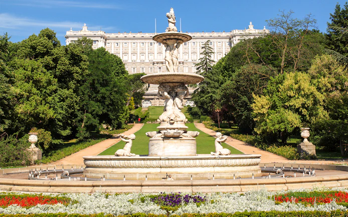 Royal Palace of Madrid with tourists in garden, part of Prado Museum and Royal Palace tour.