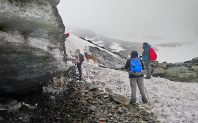 Hikers trekking on snowy path near Vinciguerra Glacier, Argentina.
