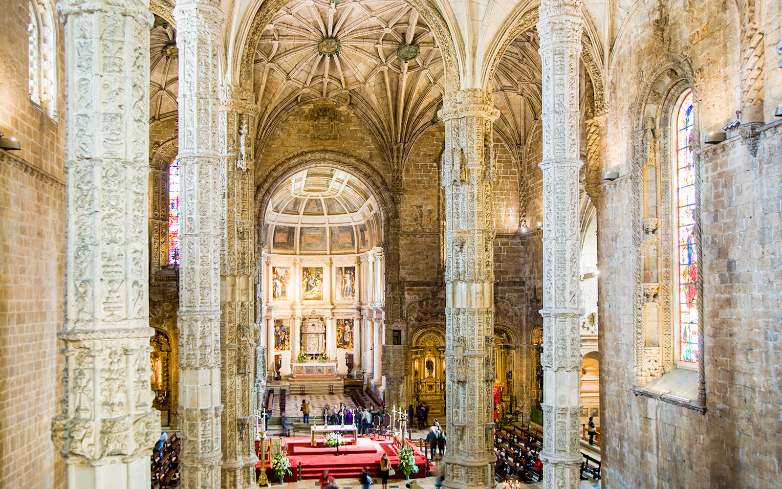 Jeronimos Monastery interior with ornate columns and altar in Lisbon.