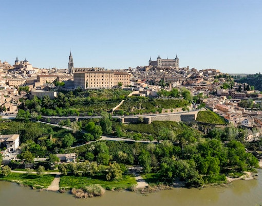 Aerial view of Toledo, Spain, featuring the Alcázar and the Tagus River.