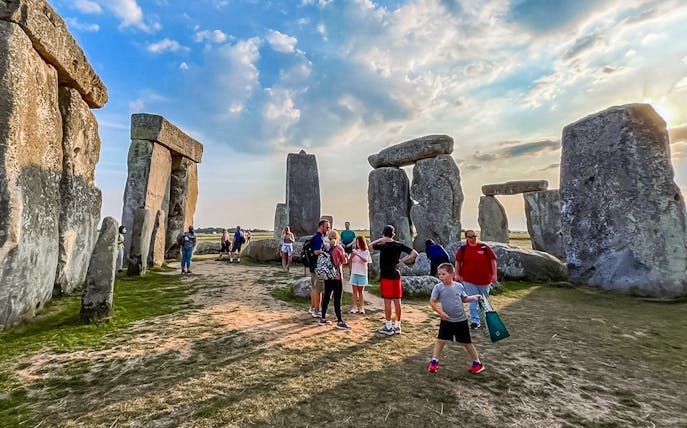 Visitors walking among Stonehenge stones during exclusive tour from London.