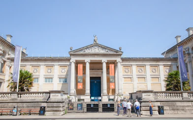 Front entrance of the Ashmolean Museum in Oxford with visitors outside.