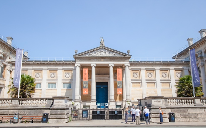 Front entrance of the Ashmolean Museum in Oxford with visitors outside.