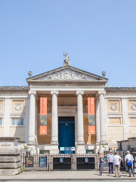 Front entrance of the Ashmolean Museum in Oxford with visitors outside.