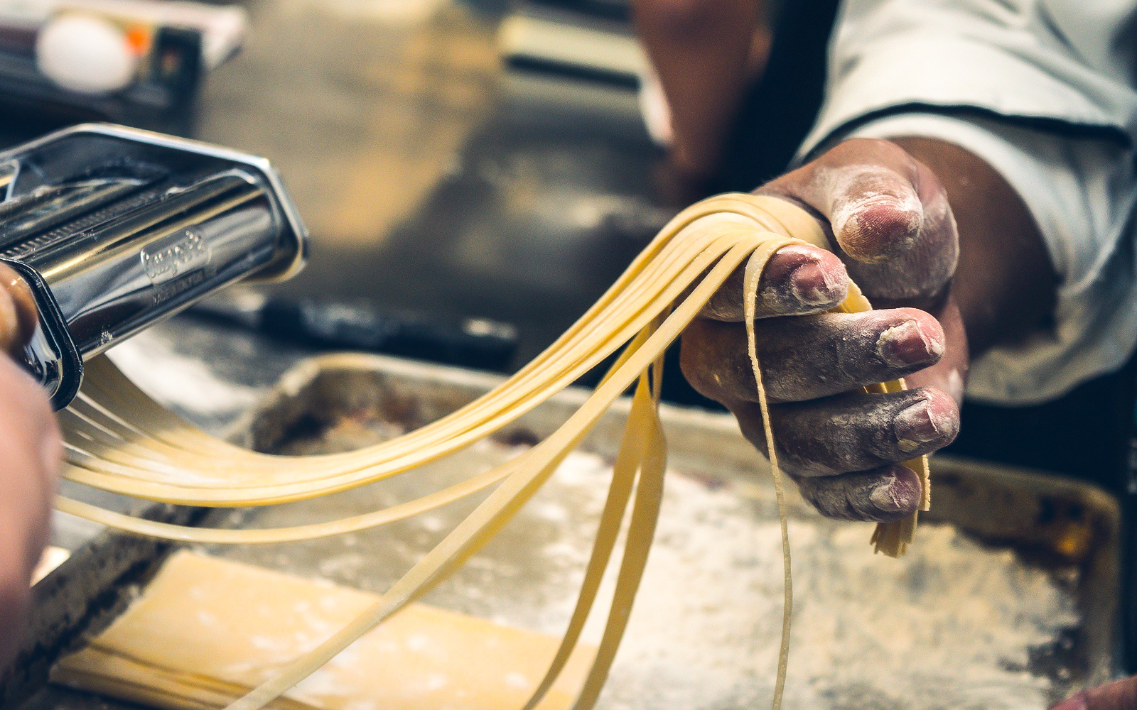Hands making fresh pasta during a guided tour with tastings.