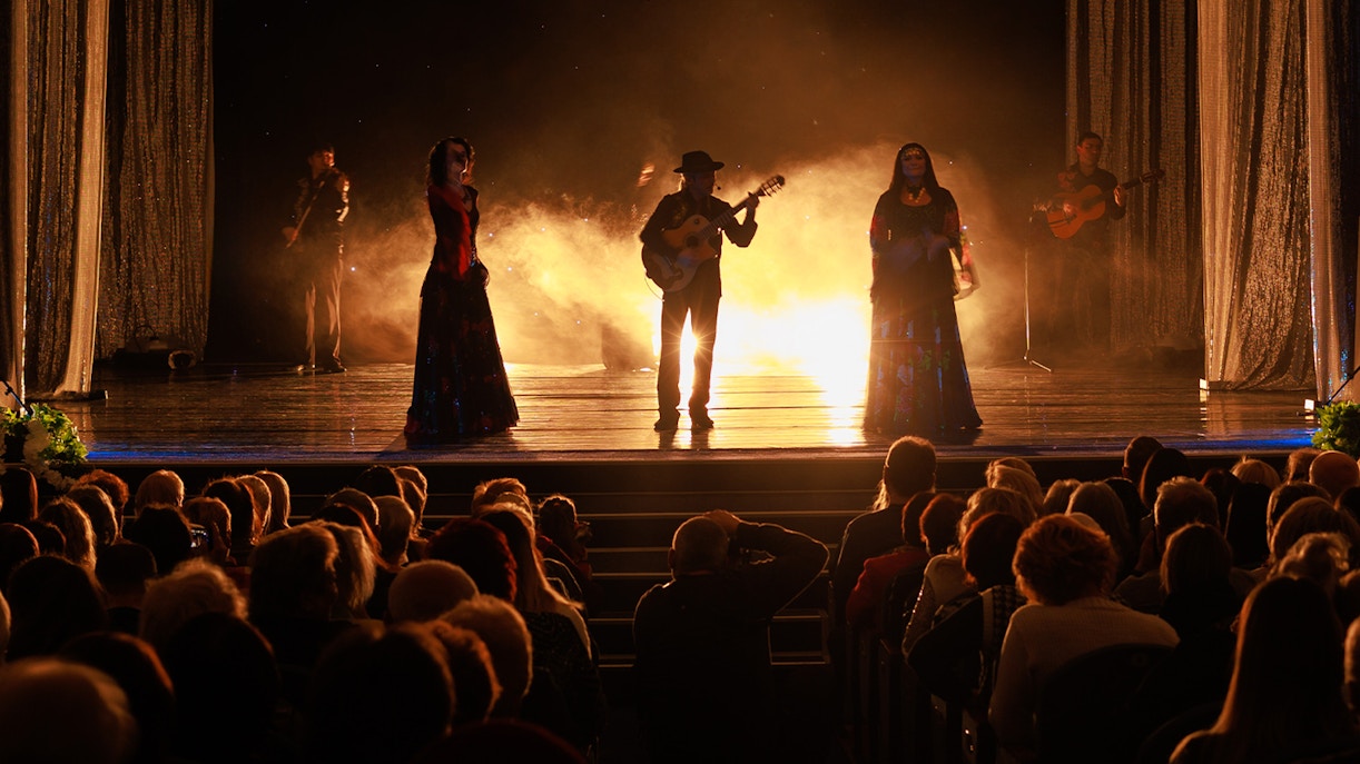 Dançarina de flamenco em sevilha, usando vestido vermelho vibrante, em pose dramática com os braços erguidos.