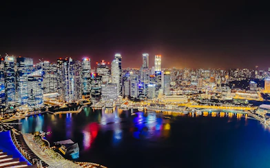 Singapore skyline illuminated at night, viewed from Marina Bay Sands SkyPark Observation Deck.