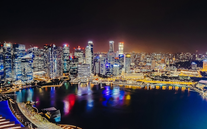 Singapore skyline illuminated at night, viewed from Marina Bay Sands SkyPark Observation Deck.