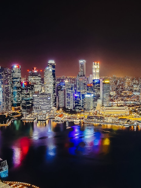 Singapore skyline illuminated at night, viewed from Marina Bay Sands SkyPark Observation Deck.
