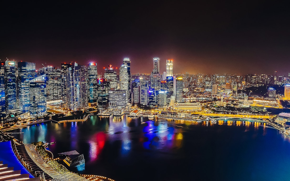 Singapore skyline illuminated at night, viewed from Marina Bay Sands SkyPark Observation Deck.
