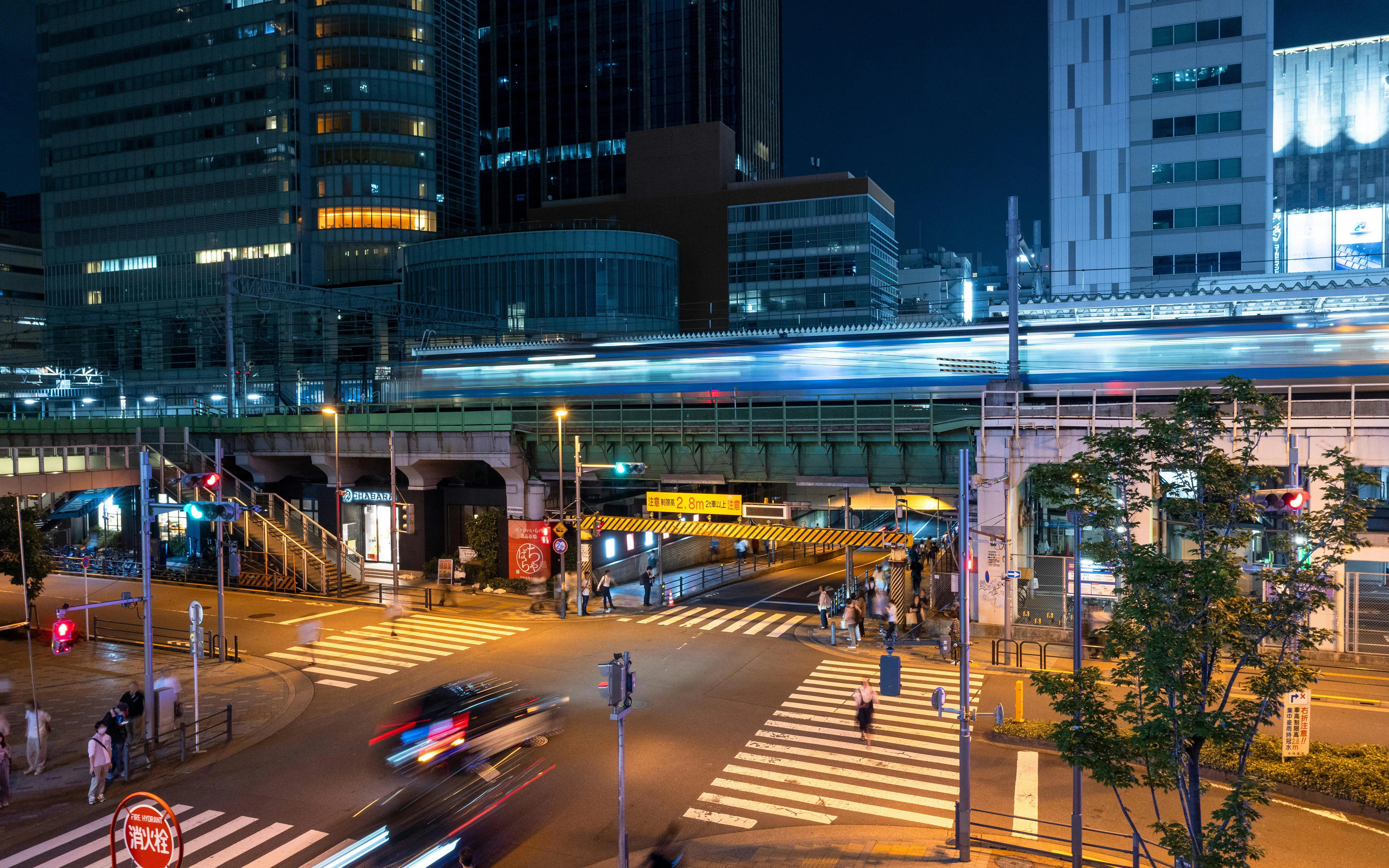 Chuo-dori intersection near Radio Kaikan with evening traffic and illuminated buildings.