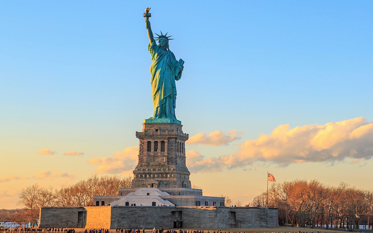 Statue of Liberty at sunset, New York City, viewed from Ellis Island.