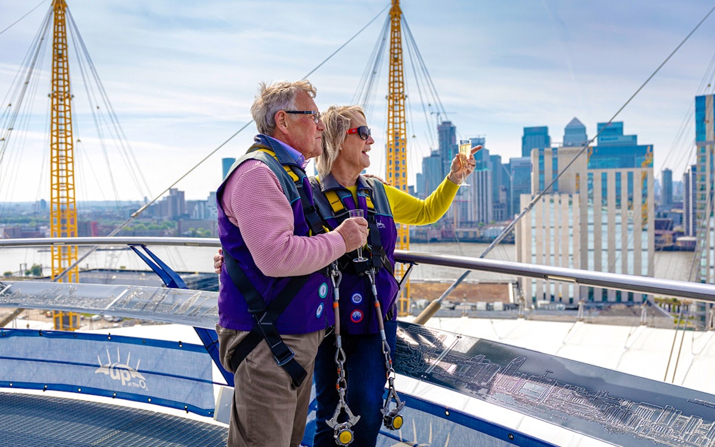 Guests enjoying drinks on the Up at the O2 Celebration Climb with city skyline views.