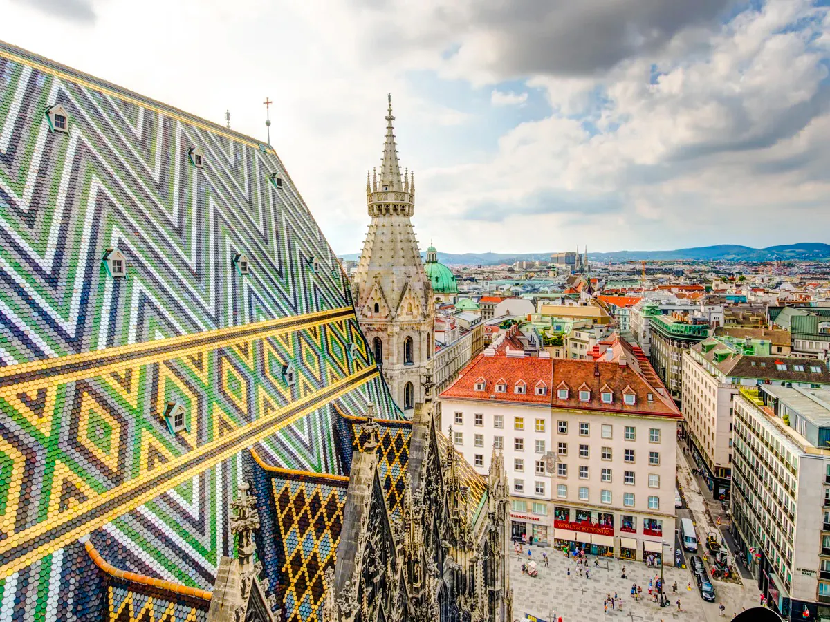 St. Stephen's Cathedral rooftop view in Vienna, featuring colorful patterned tiles and cityscape.