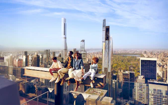 Tourists sitting on the beam enjoying views on their Top of the Rock experience
