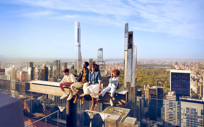 Tourists sitting on the beam enjoying views on their Top of the Rock experience