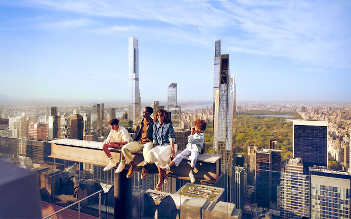 Tourists sitting on the beam enjoying views on their Top of the Rock experience