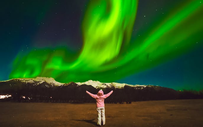 Tourist admiring Northern Lights in Reykjavik, Iceland.