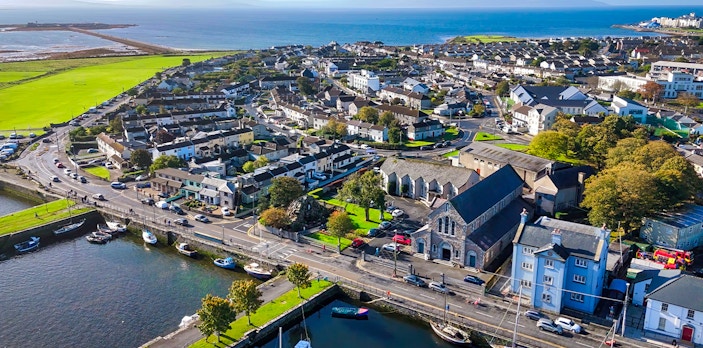 Aerial view of Galway city, Ireland, featuring coastal buildings and boats along the waterfront.