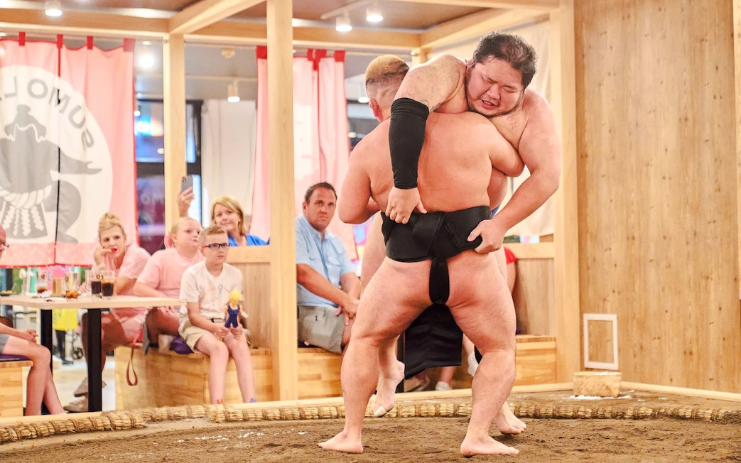 Sumo wrestlers in a match at Ryogoku with spectators watching, Japan.