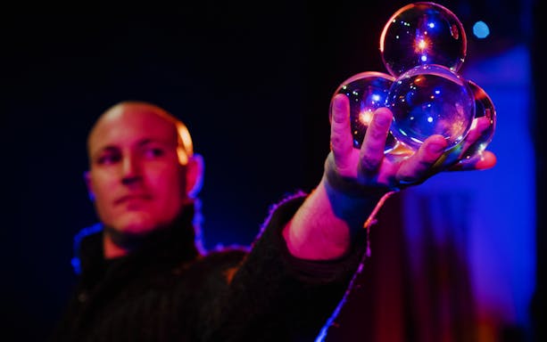 Performer holding reflective spheres at Woodstock Variety Show.