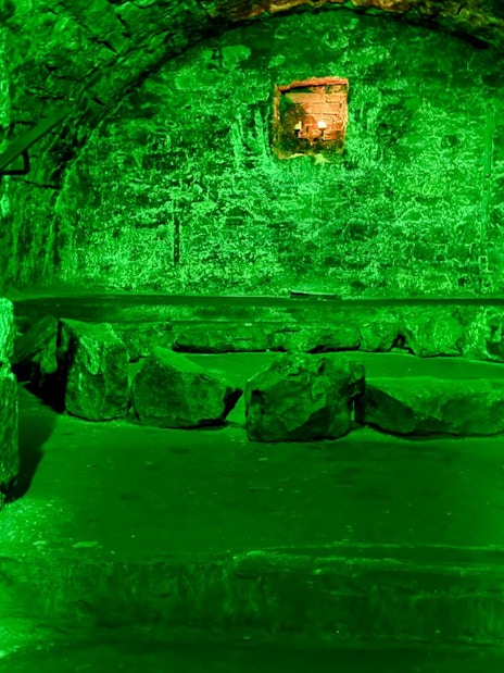 Underground stone chamber with eerie lighting on the Terror Tour in Edinburgh.