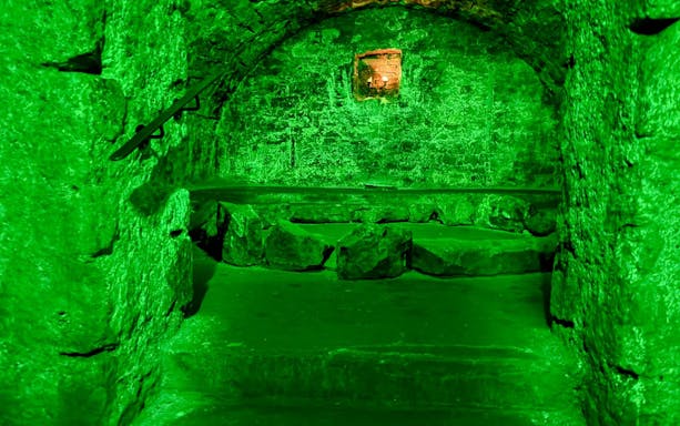 Underground stone chamber with eerie lighting on the Terror Tour in Edinburgh.