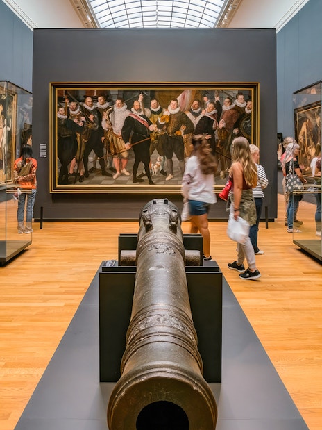 Visitors exploring art and artifacts in a gallery during the First Access Guided Tour of Rijksmuseum.